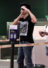 组图：吴奇隆机场收粉丝信件 对镜头黑脸手比停