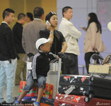 组图：孙悦素颜携子现身机场 儿子顽皮坐行李车