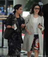 组图：关之琳风衣短裤显贵气 一路与男助理热聊