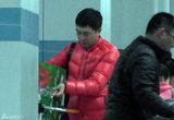 组图：张嘉译红羽绒衫回京 俩魁梧男助理接机