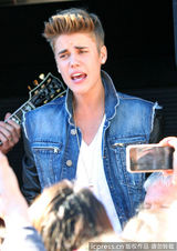 组图：比伯当街献唱谢歌迷 小天王自恋摸发