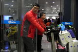组图：张嘉译红羽绒衫回京 俩魁梧男助理接机