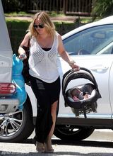 组图：希拉里-达芙携子游玩 手提玩具马开心大笑