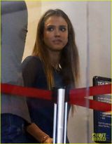 组图：阿尔芭憔悴亮相机场 肩夹手机忙通话