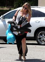 组图：希拉里-达芙携子游玩 手提玩具马开心大笑