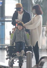 组图：张亮携妻儿现身机场 天天坐行李车可爱