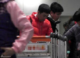 组图：张嘉译红羽绒衫回京 俩魁梧男助理接机