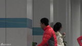 组图：张嘉译红羽绒衫回京 俩魁梧男助理接机