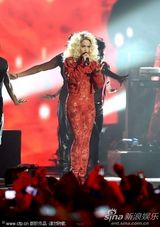 组图：Rita Ora撑黑伞演出 红色蕾丝连身裤秀身段