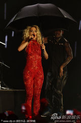 组图：Rita Ora撑黑伞演出 红色蕾丝连身裤秀身段