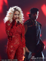 组图：Rita Ora撑黑伞演出 红色蕾丝连身裤秀身段