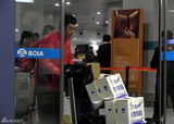 组图：张嘉译红羽绒衫回京 俩魁梧男助理接机