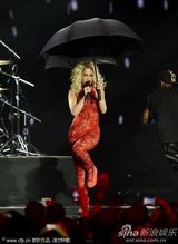组图：Rita Ora撑黑伞演出 红色蕾丝连身裤秀身段