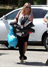 组图：希拉里-达芙携子游玩 手提玩具马开心大笑