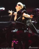 组图：Lady Gaga豪放坐汽车表演 夸张弹琴显丰满