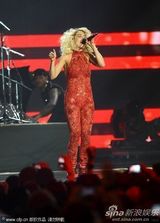 组图：Rita Ora撑黑伞演出 红色蕾丝连身裤秀身段