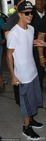 组图：比伯白衫现身机场 抱BB吻粉丝表现亲切