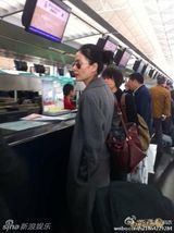 组图：王菲素颜现身机场 路人合影淡定当背景板
