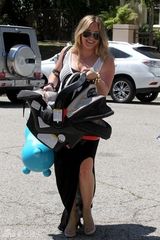 组图：希拉里-达芙携子游玩 手提玩具马开心大笑